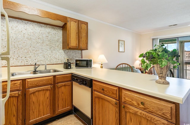 kitchen featuring light countertops, a sink, a peninsula, white appliances, and ornamental molding