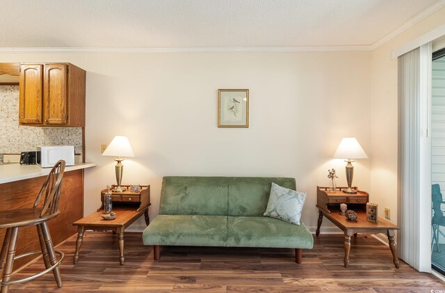sitting room featuring ornamental molding and wood finished floors