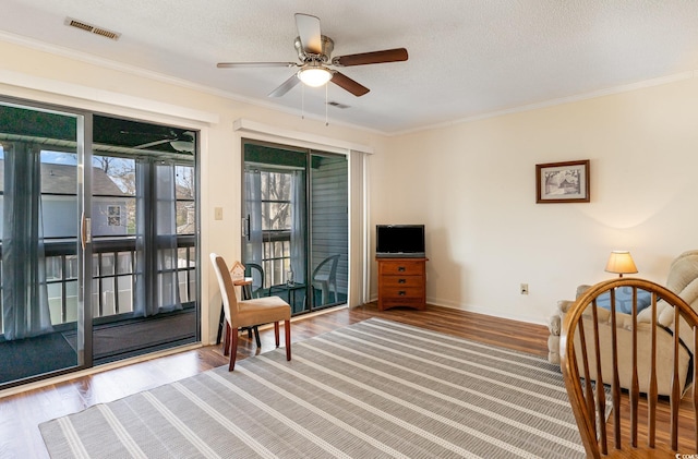 sitting room featuring wood finished floors, a textured ceiling, ceiling fan, and visible vents