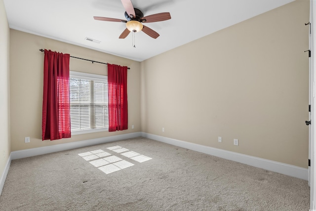 spare room featuring ceiling fan, carpet floors, visible vents, and baseboards