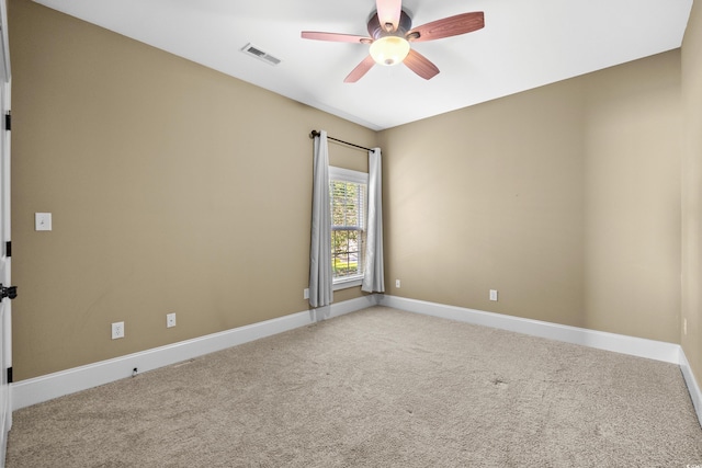 carpeted empty room with visible vents, a ceiling fan, and baseboards