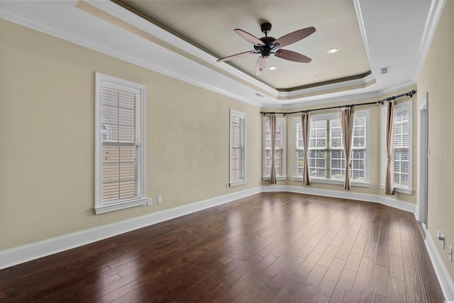 spare room with a raised ceiling, ceiling fan, dark wood-style flooring, and ornamental molding
