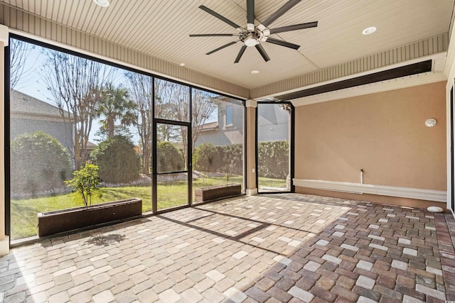 unfurnished sunroom featuring a healthy amount of sunlight and ceiling fan