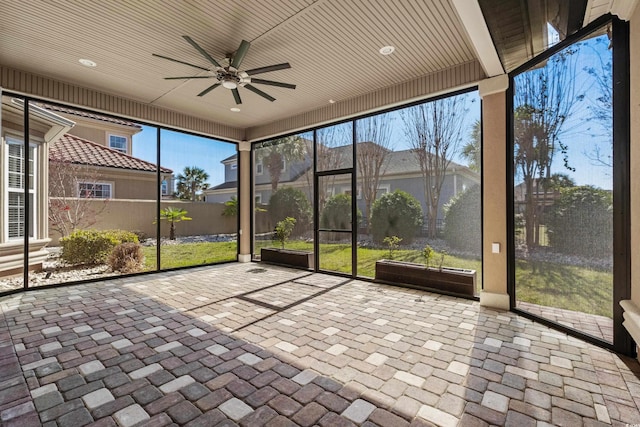 unfurnished sunroom featuring a ceiling fan