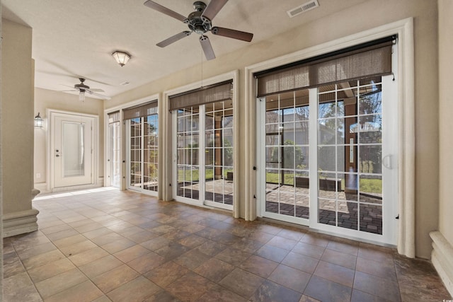 interior space featuring a ceiling fan and visible vents