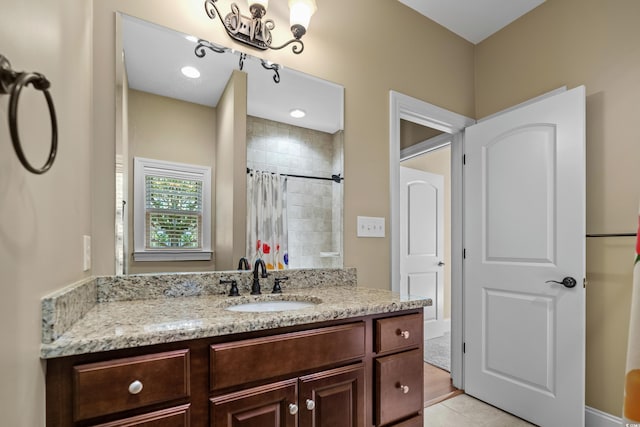bathroom featuring tile patterned floors, vanity, and a tile shower