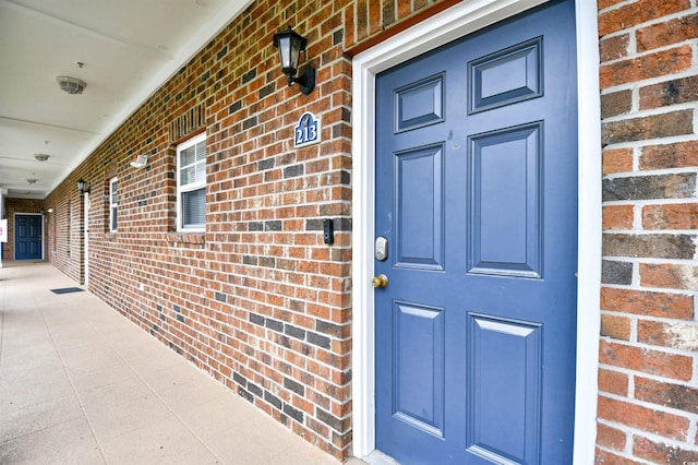 entrance to property featuring brick siding
