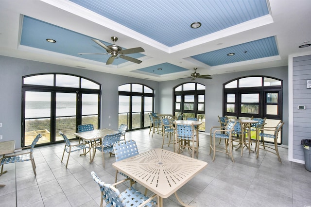 sunroom with coffered ceiling, a water view, and beam ceiling