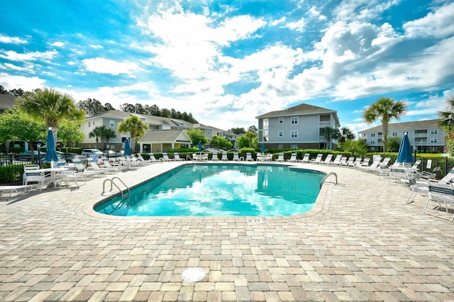 community pool with a patio area and a residential view