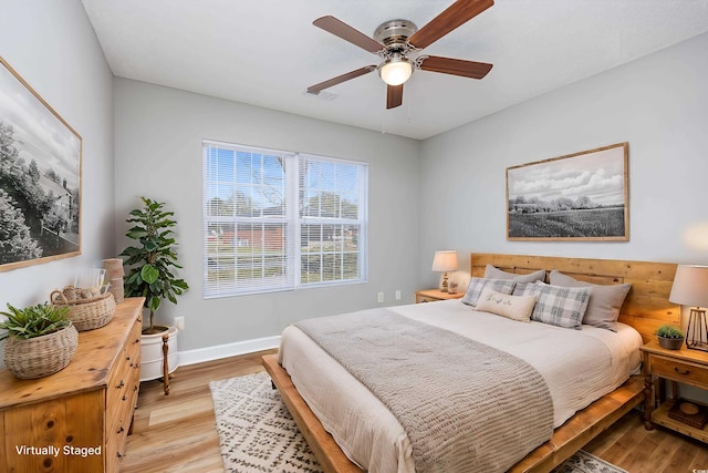 bedroom with baseboards, visible vents, ceiling fan, and light wood-style floors