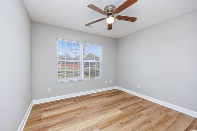 spare room featuring a ceiling fan, baseboards, and wood finished floors