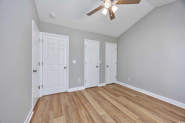 unfurnished bedroom with baseboards, ceiling fan, lofted ceiling, and light wood-type flooring