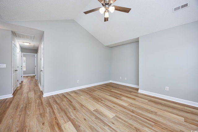 additional living space featuring a ceiling fan, visible vents, lofted ceiling, and light wood-style floors