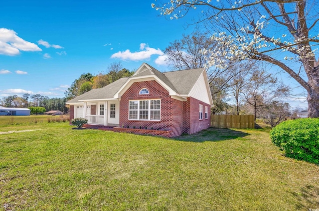 view of front of property featuring fence, a garage, a front yard, and brick siding