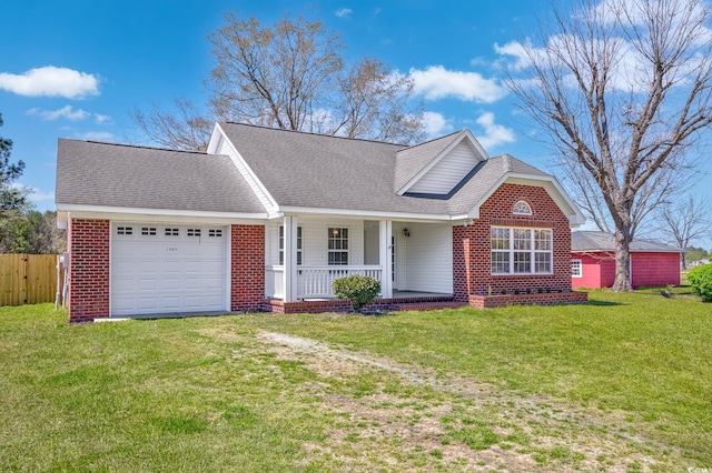 single story home featuring a porch, driveway, a front yard, brick siding, and an attached garage