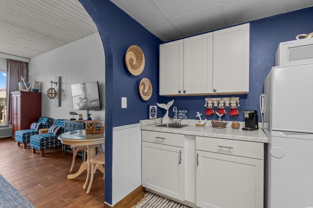 6803 N Ocean Blvd Unit 203, Myrtle Beach, SC 29572 - kitchen with freestanding refrigerator, wood finished floors, light countertops, white cabinetry, and arched walkways