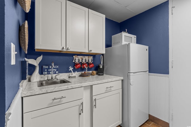 6803 N Ocean Blvd Unit 203, Myrtle Beach, SC 29572 - kitchen featuring light countertops, a sink, white appliances, and white cabinetry