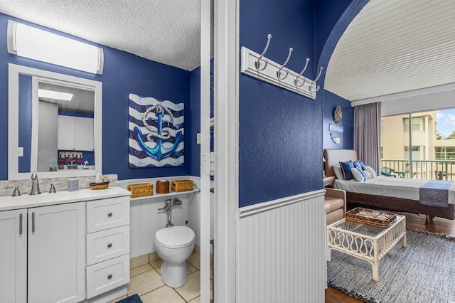 6803 N Ocean Blvd Unit 203, Myrtle Beach, SC 29572 - bathroom with wainscoting, vanity, toilet, a textured ceiling, and tile patterned floors
