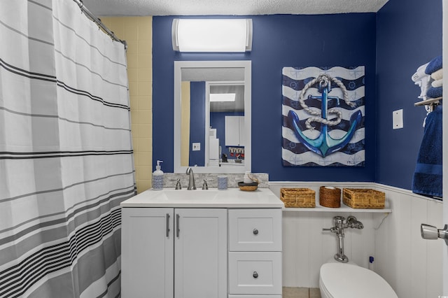 6803 N Ocean Blvd Unit 203, Myrtle Beach, SC 29572 - bathroom with vanity, wainscoting, toilet, and a textured ceiling