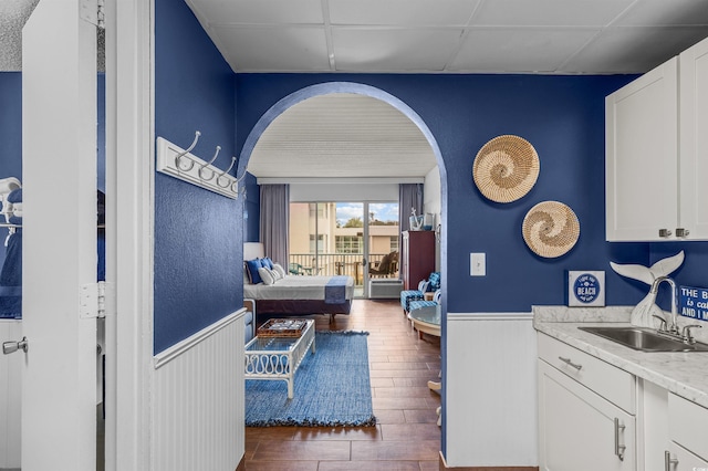 6803 N Ocean Blvd Unit 203, Myrtle Beach, SC 29572 - interior space featuring wainscoting, dark wood-style floors, a paneled ceiling, arched walkways, and a sink