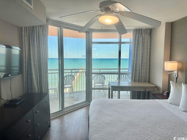 3500 N Ocean Blvd Unit 1203, North Myrtle Beach, SC 29582 - bedroom with expansive windows, access to outside, multiple windows, wood finished floors, and a water view