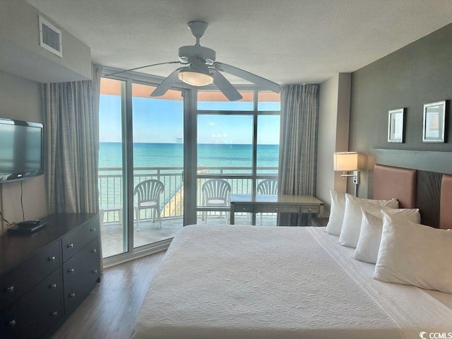 3500 N Ocean Blvd Unit 1203, North Myrtle Beach, SC 29582 - bedroom featuring floor to ceiling windows, access to exterior, wood finished floors, a water view, and a textured ceiling