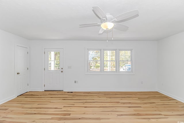 interior space with baseboards, light wood-type flooring, and ceiling fan