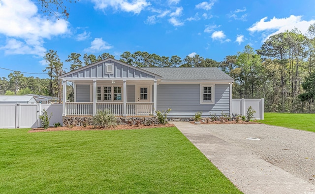 view of front of house featuring a gate, driveway, a front yard, a porch, and fence