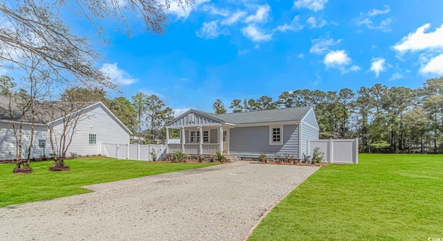 bungalow-style house with a porch, fence, a front lawn, a shingled roof, and driveway