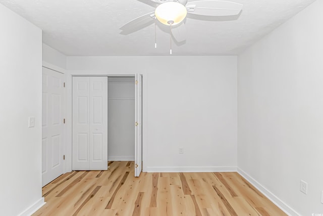 unfurnished bedroom with a closet, light wood-style flooring, baseboards, and a ceiling fan