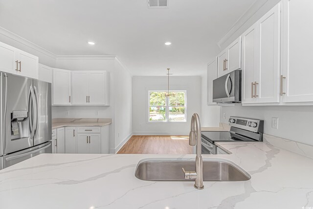 kitchen with a sink, white cabinets, appliances with stainless steel finishes, and recessed lighting