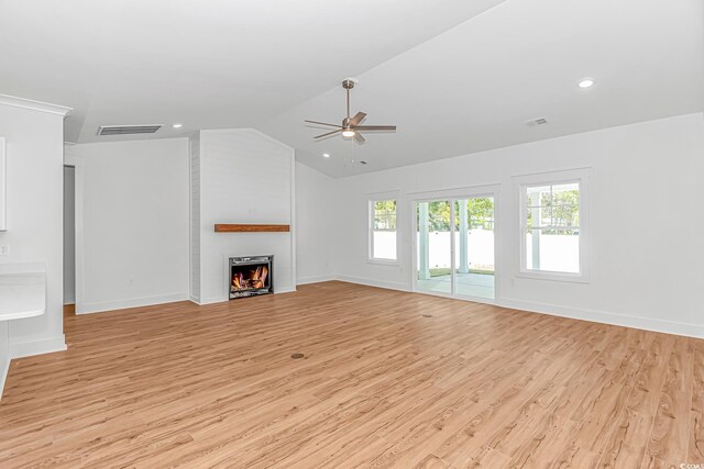 unfurnished living room with light wood-style floors, a large fireplace, a ceiling fan, visible vents, and lofted ceiling