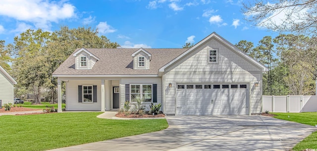 new england style home featuring a front lawn, fence, driveway, and roof with shingles