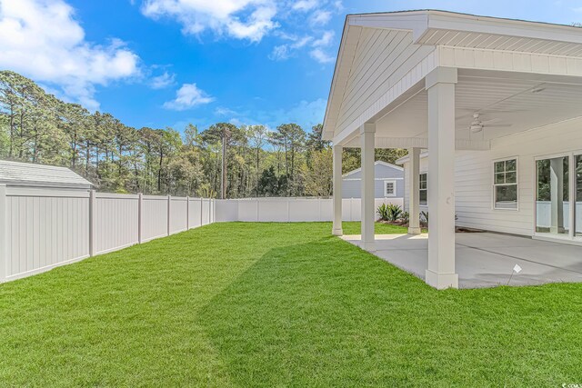 view of yard with a patio area, a fenced backyard, and a ceiling fan