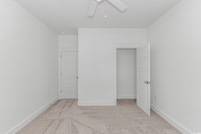 unfurnished bedroom featuring light carpet, ceiling fan, and baseboards