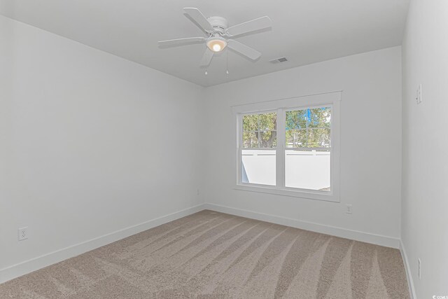unfurnished room with visible vents, baseboards, a ceiling fan, and light colored carpet