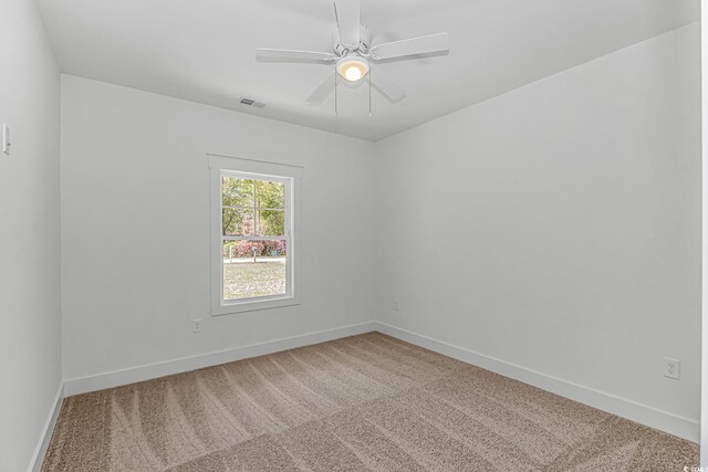 carpeted spare room featuring ceiling fan, baseboards, and visible vents