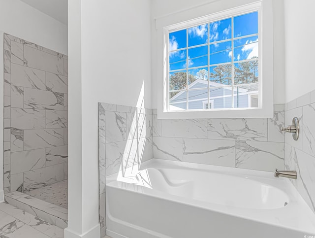 bathroom with a bathing tub, marble finish floor, and walk in shower
