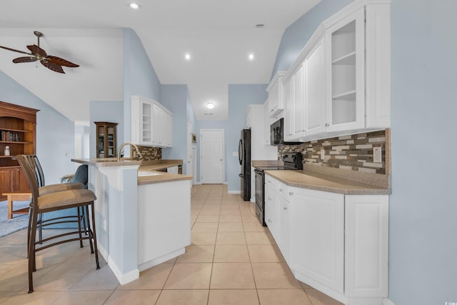 308 Dendy Ct, Myrtle Beach, SC 29579 - kitchen featuring black appliances, a ceiling fan, vaulted ceiling, a kitchen breakfast bar, and a peninsula