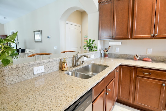 408 7th Ave S, North Myrtle Beach, SC 29582 - kitchen with light stone countertops, arched walkways, brown cabinets, a peninsula, and dishwasher