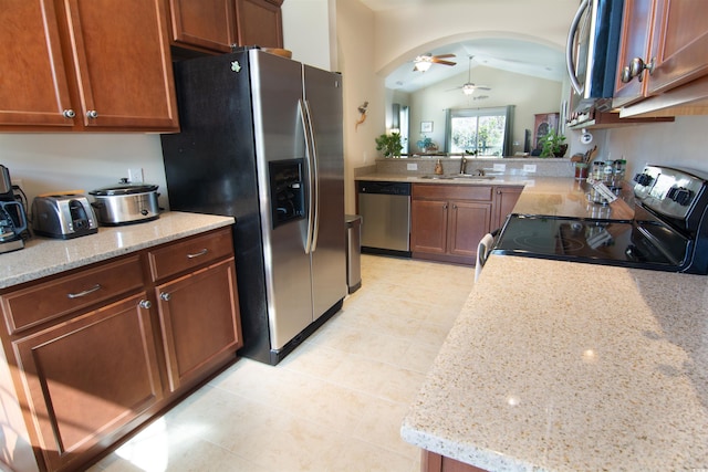 408 7th Ave S, North Myrtle Beach, SC 29582 - kitchen featuring stainless steel appliances, a ceiling fan, vaulted ceiling, light tile patterned floors, and light stone countertops