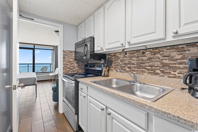 6804 Ocean Blvd N Unit 1529, Myrtle Beach, SC 29572 - kitchen with stainless steel electric range oven, white cabinets, a sink, light countertops, and black microwave