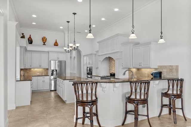 7268 Seville Dr, Myrtle Beach, SC 29572 - kitchen with appliances with stainless steel finishes, a peninsula, tasteful backsplash, dark stone countertops, and a breakfast bar area