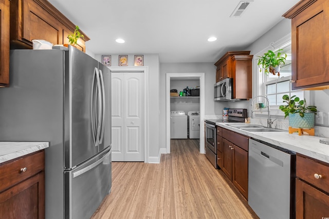 1524 Stilley Cir, Conway, SC 29526 - kitchen with appliances with stainless steel finishes, washing machine and clothes dryer, a sink, light wood finished floors, and recessed lighting