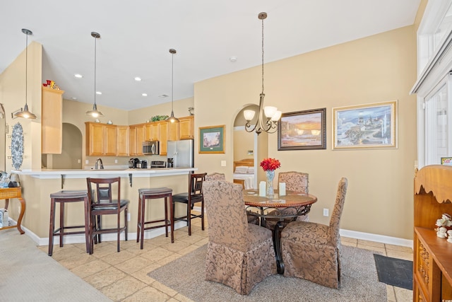 dining room with baseboards, recessed lighting, arched walkways, and an inviting chandelier