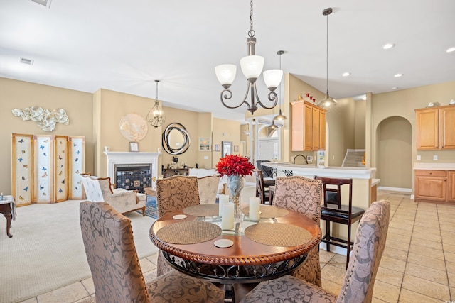 dining space with recessed lighting, arched walkways, an inviting chandelier, a glass covered fireplace, and visible vents