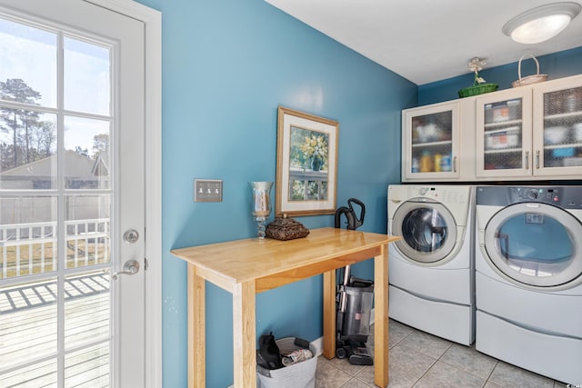 laundry room featuring cabinet space, light tile patterned flooring, and independent washer and dryer