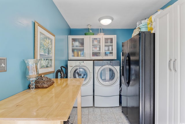 washroom with light tile patterned floors, washing machine and clothes dryer, and laundry area