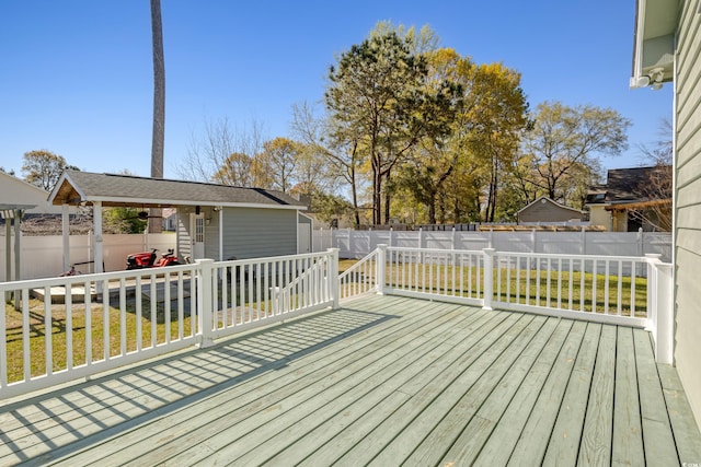 wooden terrace with an outdoor structure, a shed, a yard, and a fenced backyard
