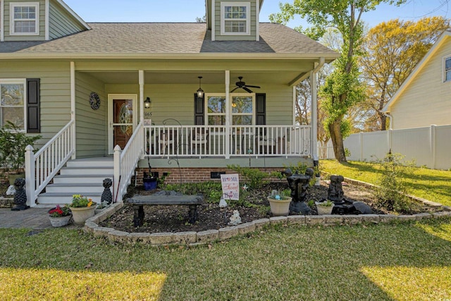 view of front facade featuring fence, covered porch, a ceiling fan, and a front lawn